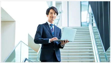 スーツを着た男性が、パソコンで作業している